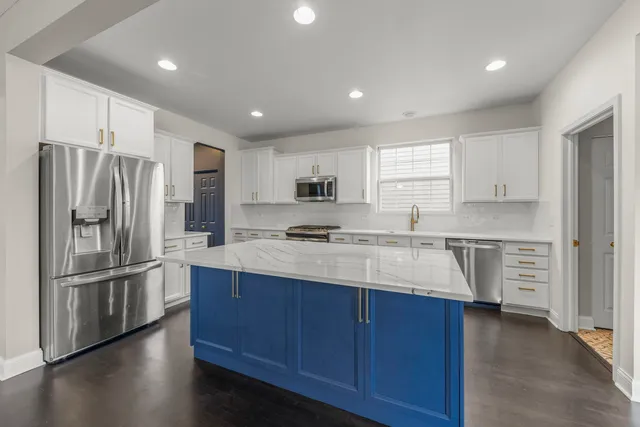 a kitchen with stainless steel appliances granite countertop a refrigerator sink and cabinets
