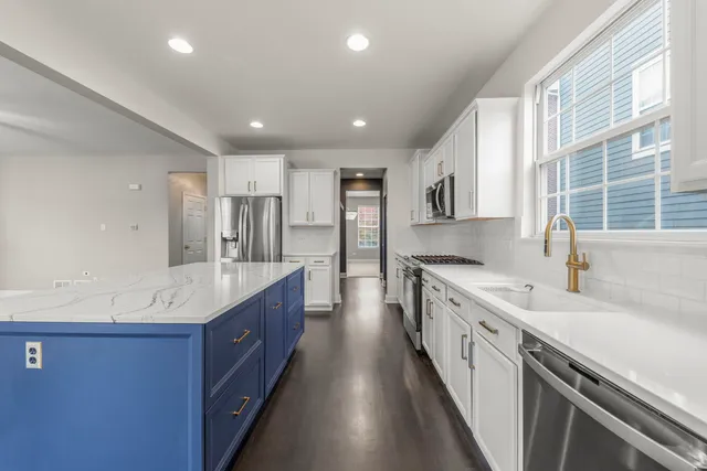 a large kitchen with stainless steel appliances sink a microwave and cabinets