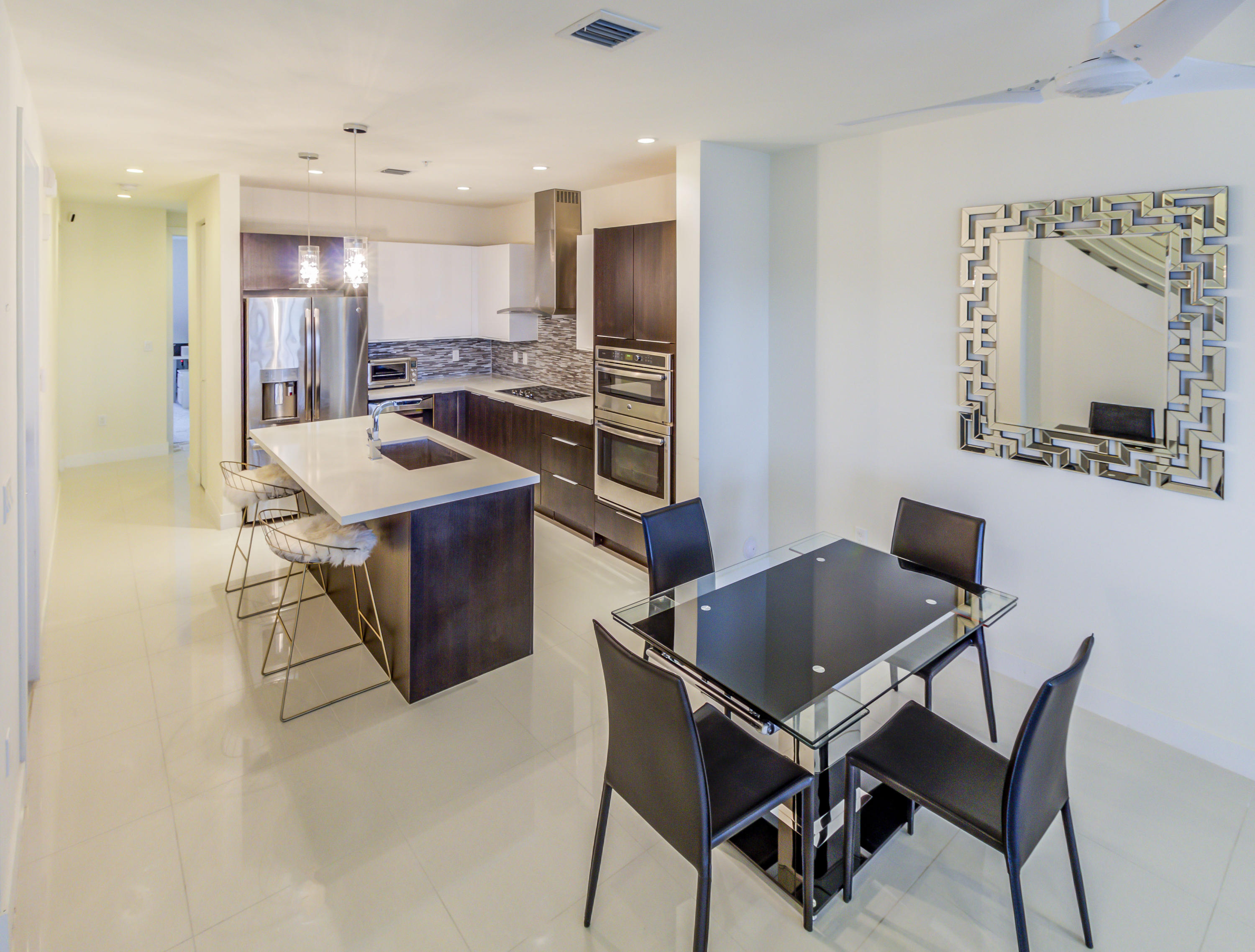 6415 Northwest 102nd Path, Unit 201 Doral, FL 33178 - Photo 14 of 41 a kitchen with a dining table chairs and refrigerator
