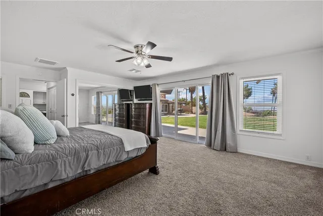 a spacious bedroom with a large bed and a chandelier