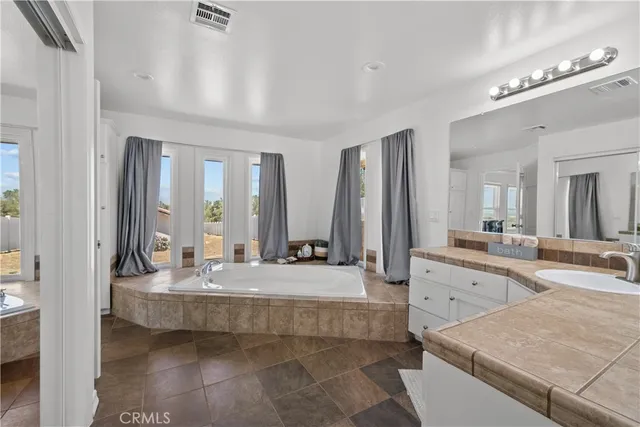 a large bathroom with double vanity and a bathtub