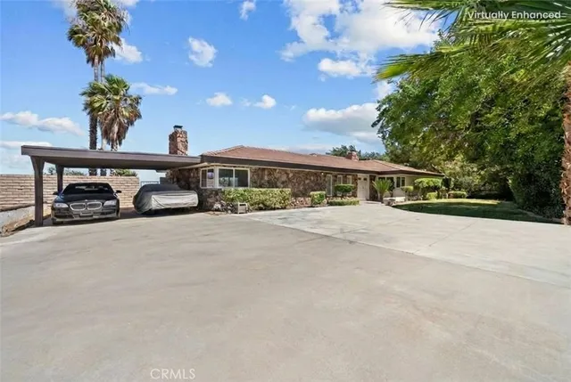 a couple of cars parked in front of house with yard and green space