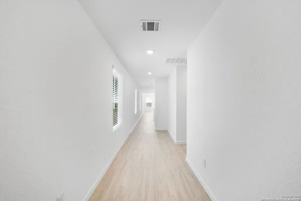 a view of a hallway with wooden floor