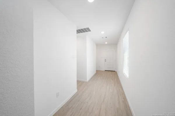 a view of a hallway with wooden floor