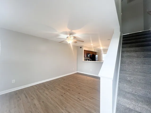 a view of a hallway with wooden floor and a chandelier