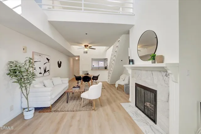 a living room with furniture a fireplace and potted plants
