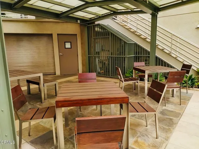 a view of a patio with a table and chairs under an umbrella