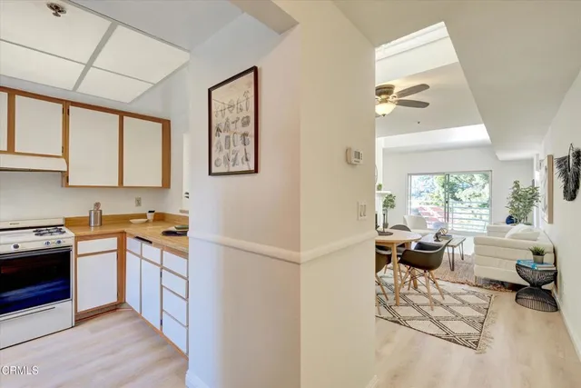 a kitchen with stainless steel appliances granite countertop a stove a sink dishwasher and a refrigerator with wooden floor