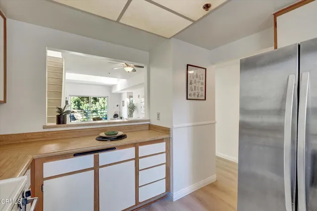 a view of open kitchen view with wooden floor and stainless steel appliances