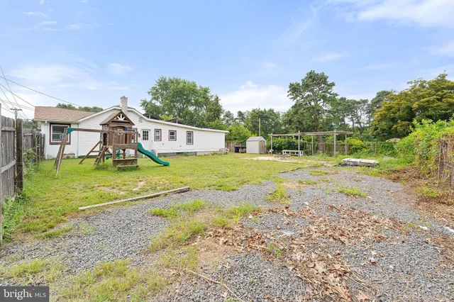 a view of a house with backyard and a tree