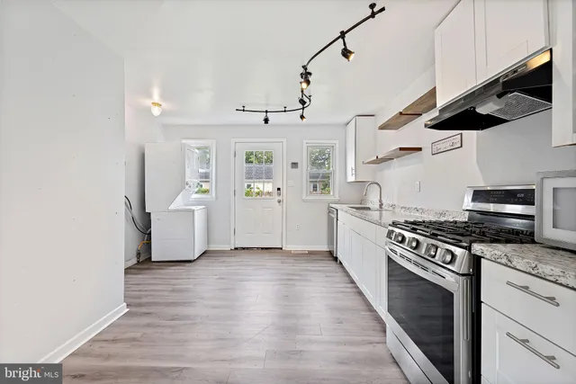 a kitchen with stainless steel appliances granite countertop a stove and a refrigerator