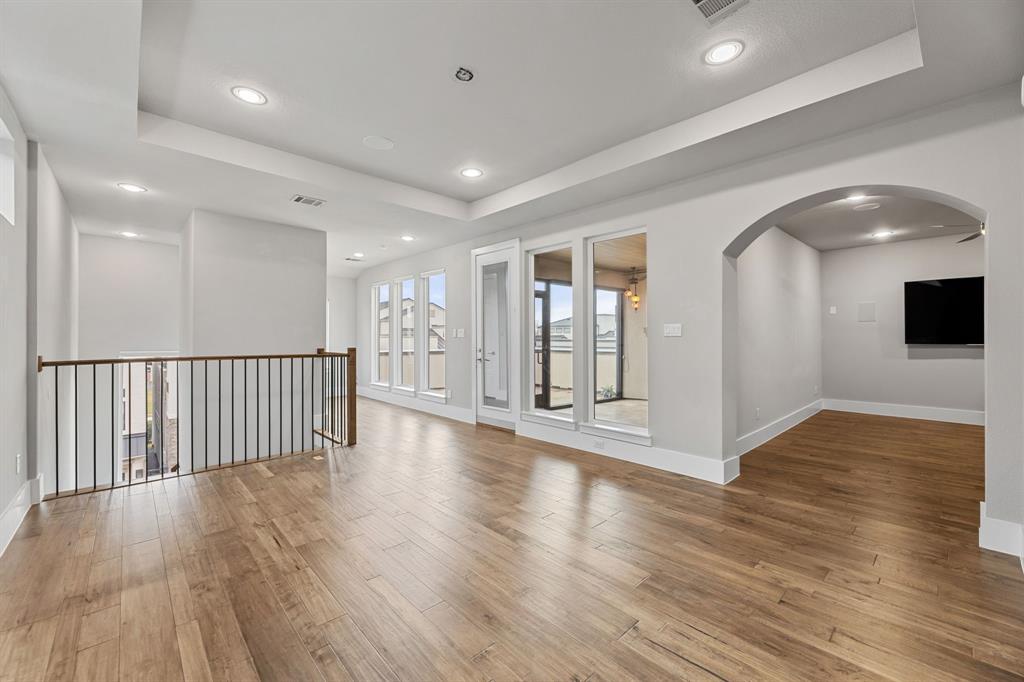 7854 Element Avenue Plano, TX 75024 - Photo 32 of 38 Unfurnished room featuring a raised ceiling, wood finished floors, arched walkways, and recessed lighting