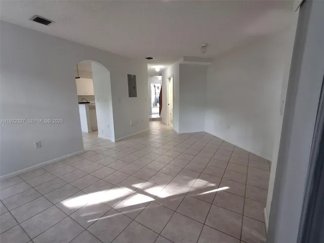 a view of a hallway with wooden floor and a staircase