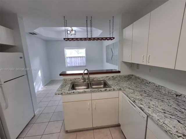 a kitchen with stainless steel appliances granite countertop a sink a stove and a refrigerator
