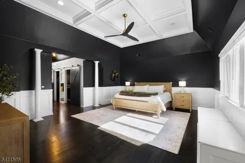 a bedroom with a large bed and a flat tv screen