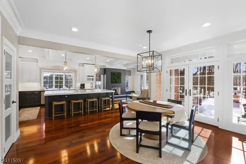 a view of a dining room with furniture a chandelier and wooden floor