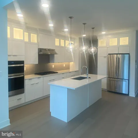 a kitchen with stainless steel appliances granite countertop a sink a stove and refrigerator