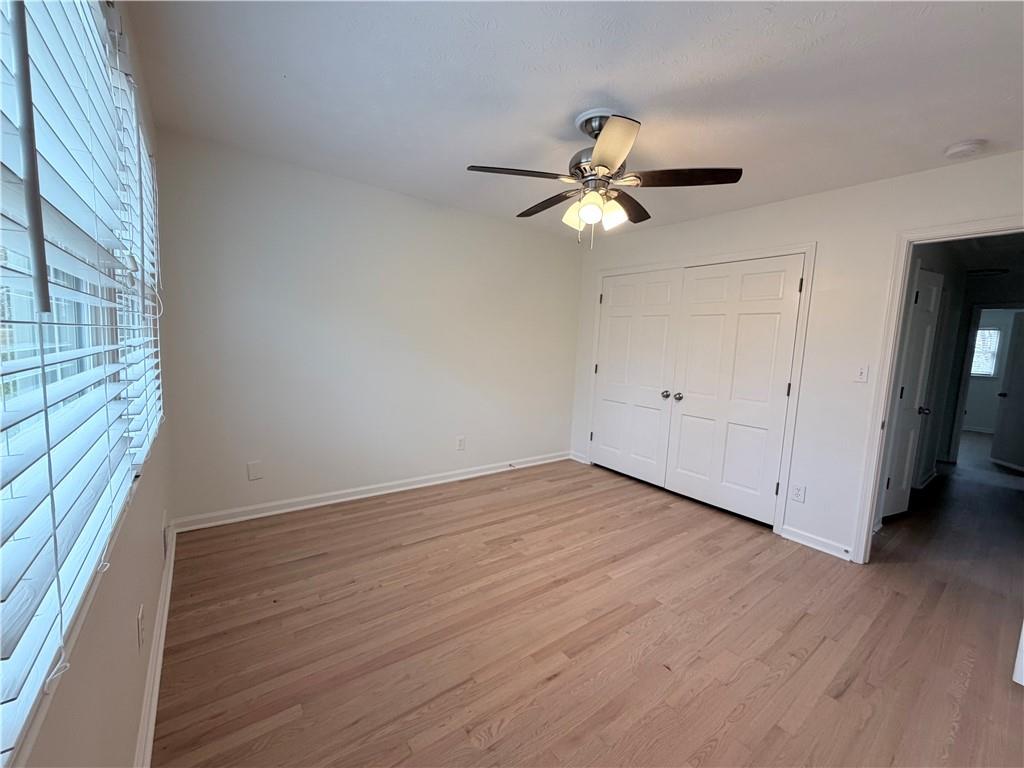 1863 Mt Vernon Road Dunwoody, GA 30338 - Photo 18 of 25 an empty room with wooden floor fan and windows