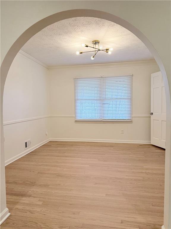 1863 Mt Vernon Road Dunwoody, GA 30338 - Photo 4 of 25 an empty room with wooden floor and chandelier