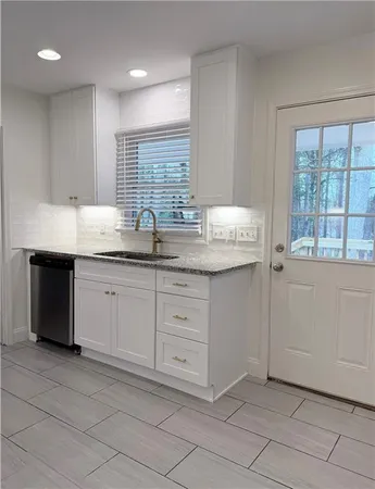 a kitchen with a sink window and cabinets
