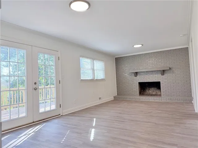 a view of empty room with wooden floor and fireplace