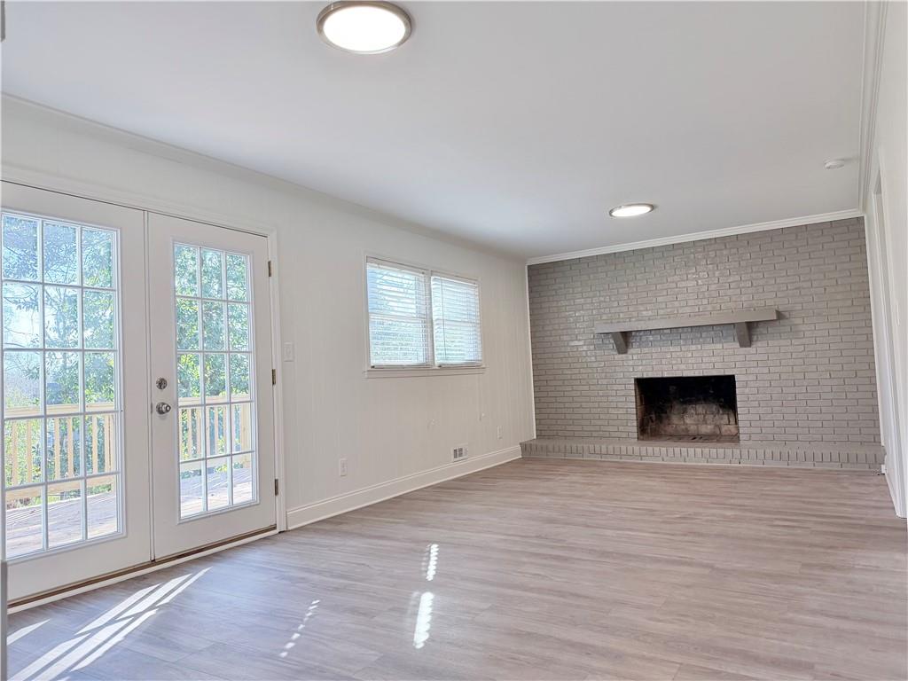 1863 Mt Vernon Road Dunwoody, GA 30338 - Photo 9 of 25 a view of empty room with wooden floor and fireplace