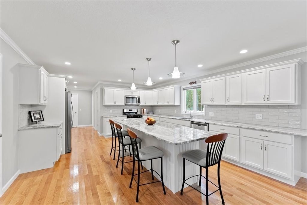 145 Barrington Drive Springfield, MA 01129 - Photo 15 of 42 a kitchen with stainless steel appliances granite countertop a table chairs sink and cabinets