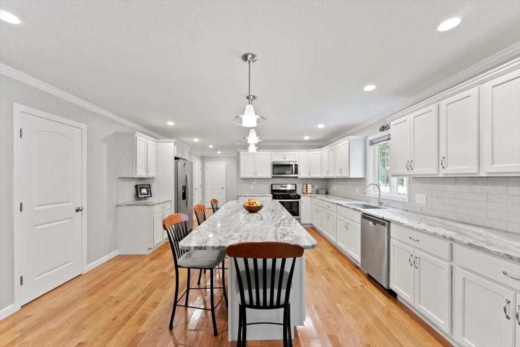 145 Barrington Drive Springfield, MA 01129 - Photo 16 of 42 a large kitchen with kitchen island a dining table and chairs
