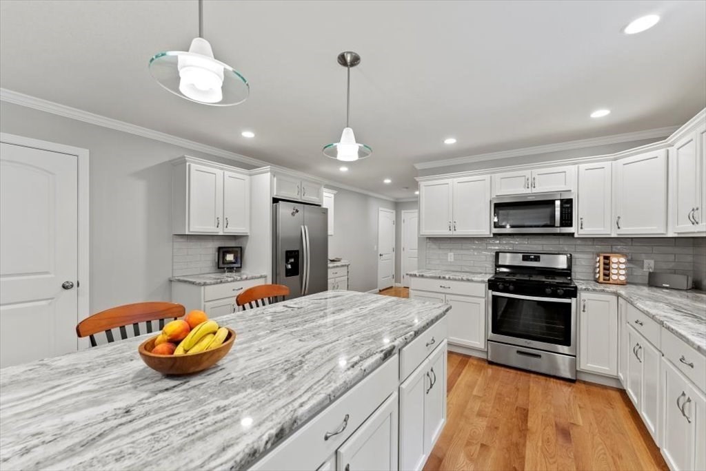 145 Barrington Drive Springfield, MA 01129 - Photo 18 of 42 a kitchen with stainless steel appliances kitchen island granite countertop a stove and white cabinets