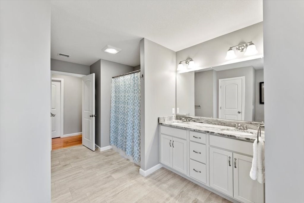 145 Barrington Drive Springfield, MA 01129 - Photo 30 of 42 a bathroom with a granite countertop sink a large mirror a shower and vanity