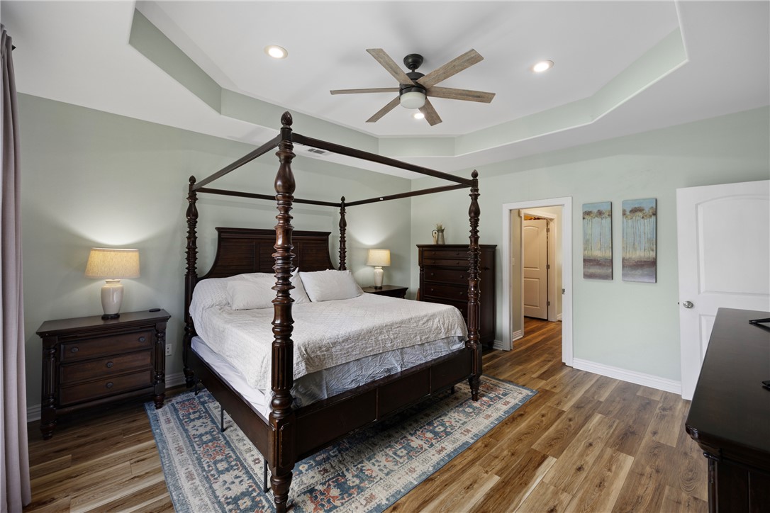 751 Walthall Road Russellville, AR 72802 - Photo 17 of 60 Room featuring wood-finish flooring, a tray ceiling with recessed lighting, and a ceiling fan