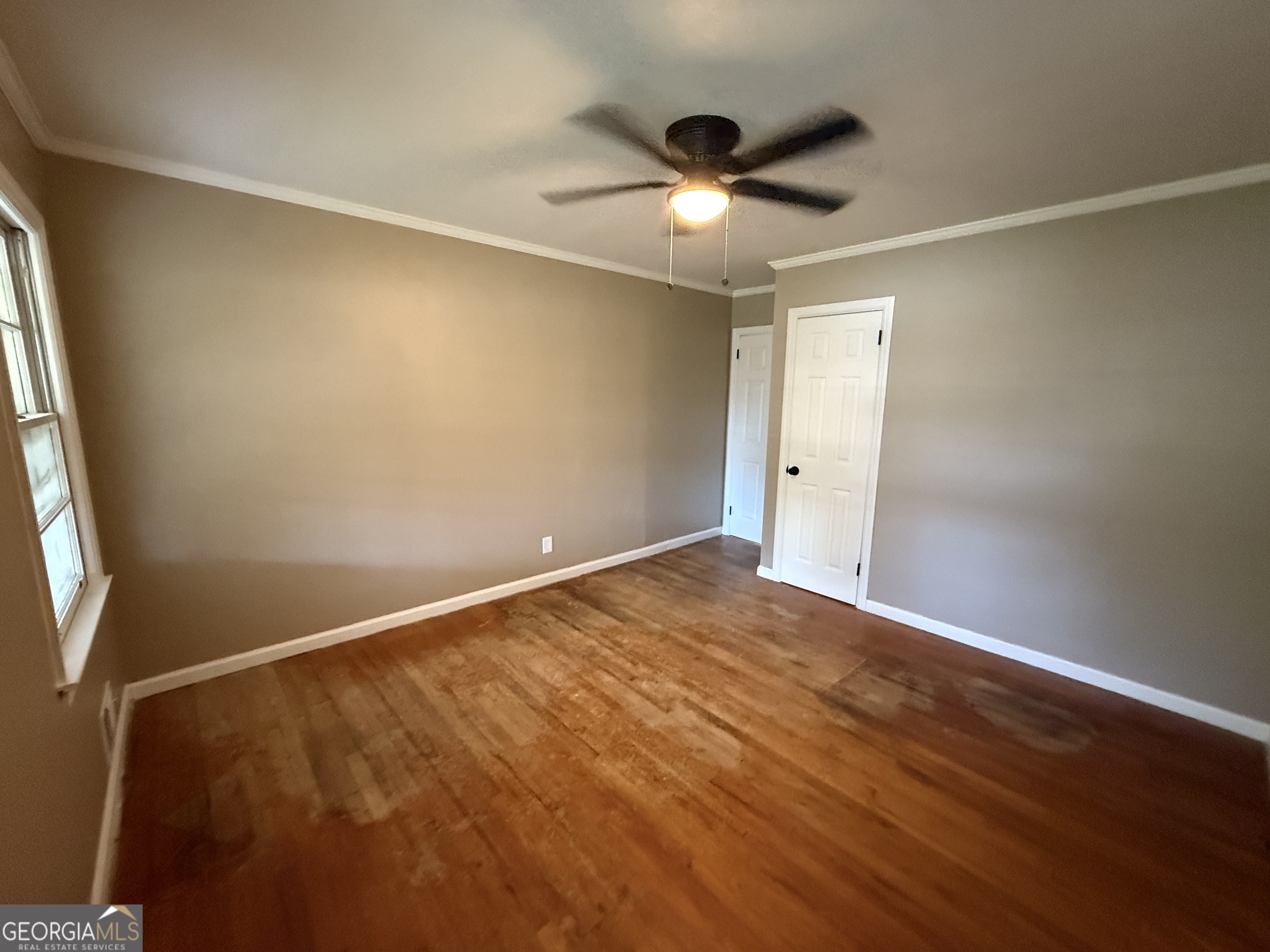412 Roberson Street Dublin, GA 31021 - Photo 38 of 67 an empty room with a window and a ceiling fan