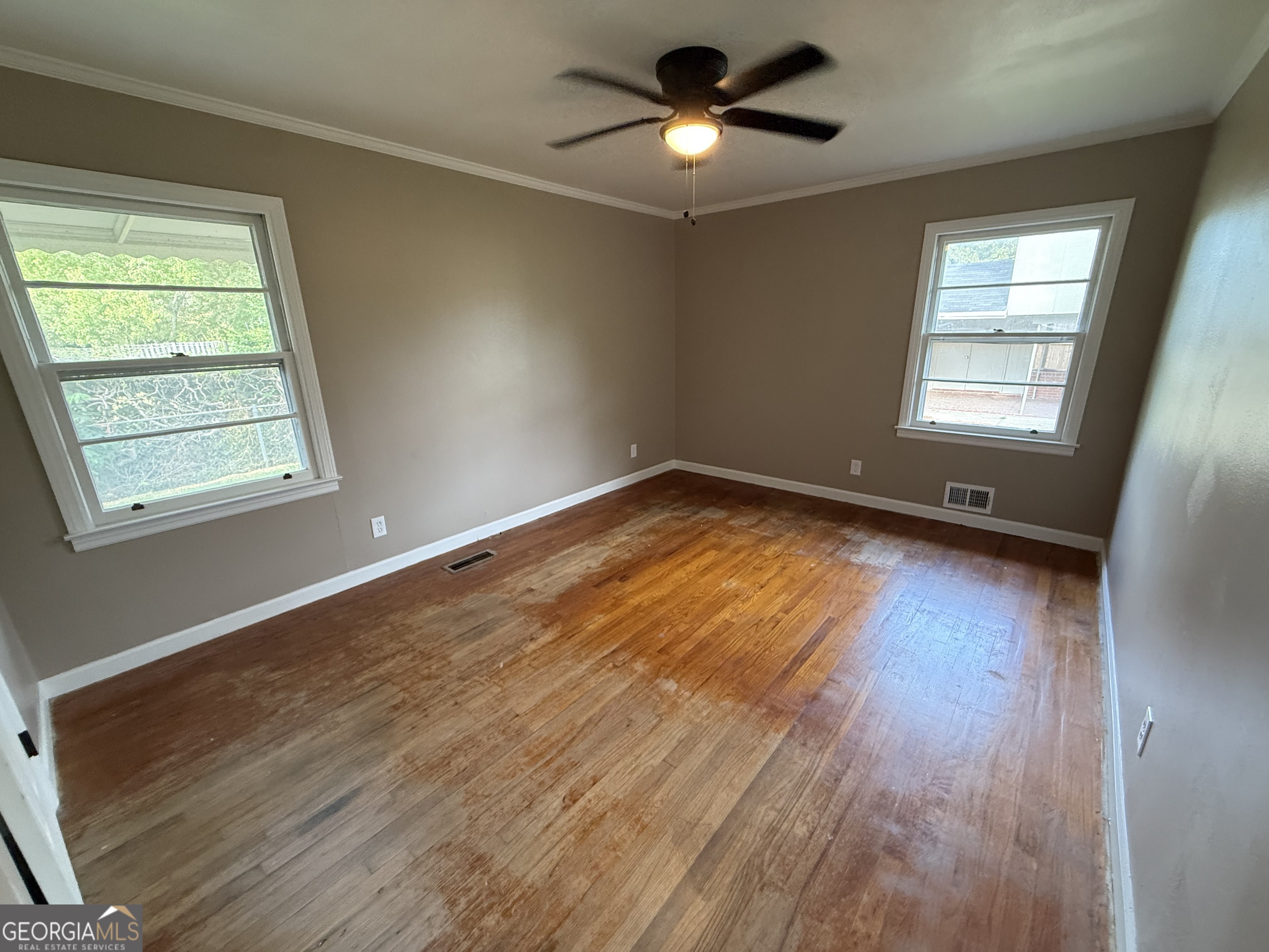 412 Roberson Street Dublin, GA 31021 - Photo 39 of 67 a view of empty room with wooden floor and fan