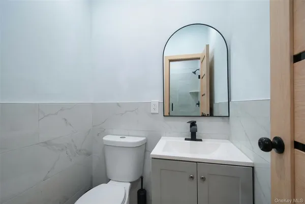 a bathroom with a toilet sink and mirror