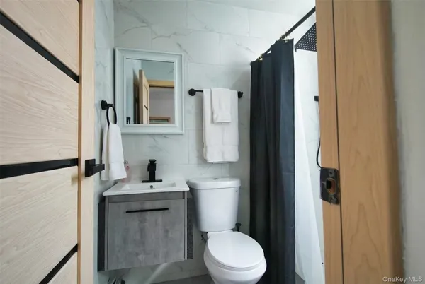a bathroom with a sink a toilet a mirror and shower