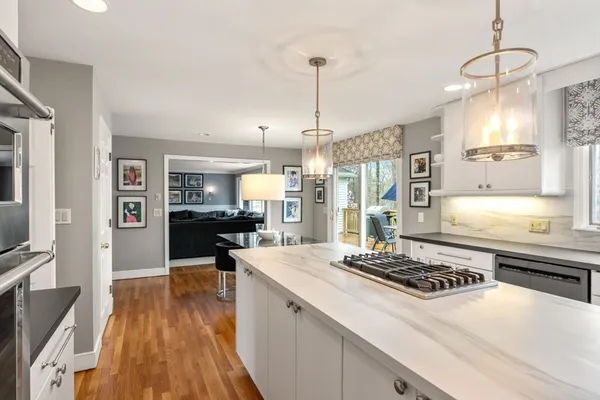 a large kitchen with kitchen island a stove a sink a refrigerator and wooden floor