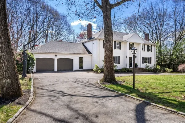 a view of a white house with a yard and large tree