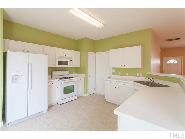 212 Purple Leaf Road Fuquay-Varina, NC 27526 - Photo 8 of 21 a kitchen with stainless steel appliances a white cabinets stove and a refrigerator