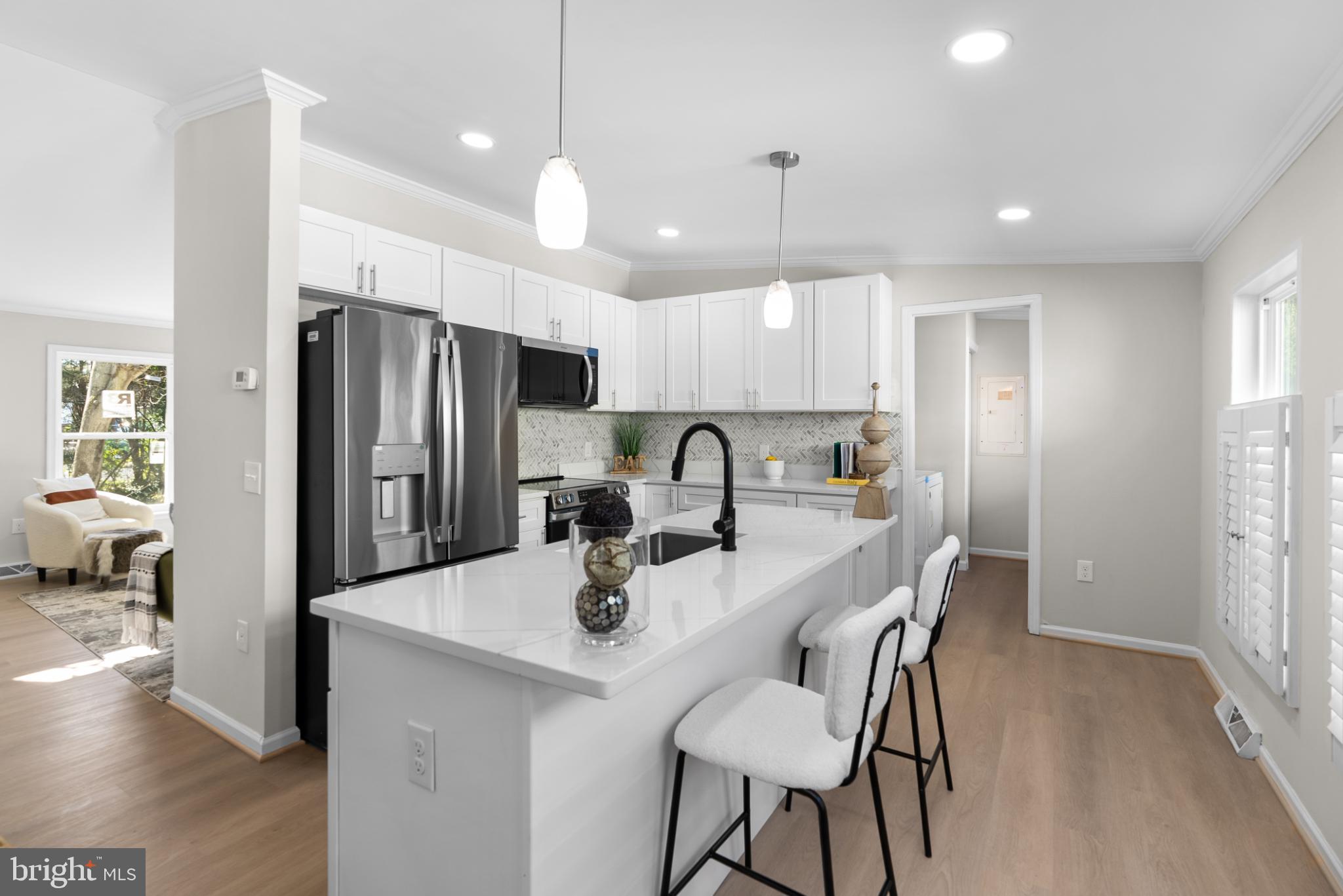 a kitchen with refrigerator a sink and chairs
