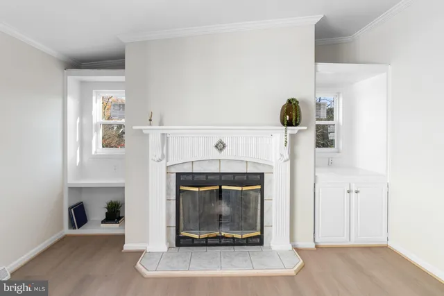 wooden floor fireplace and windows in an empty room