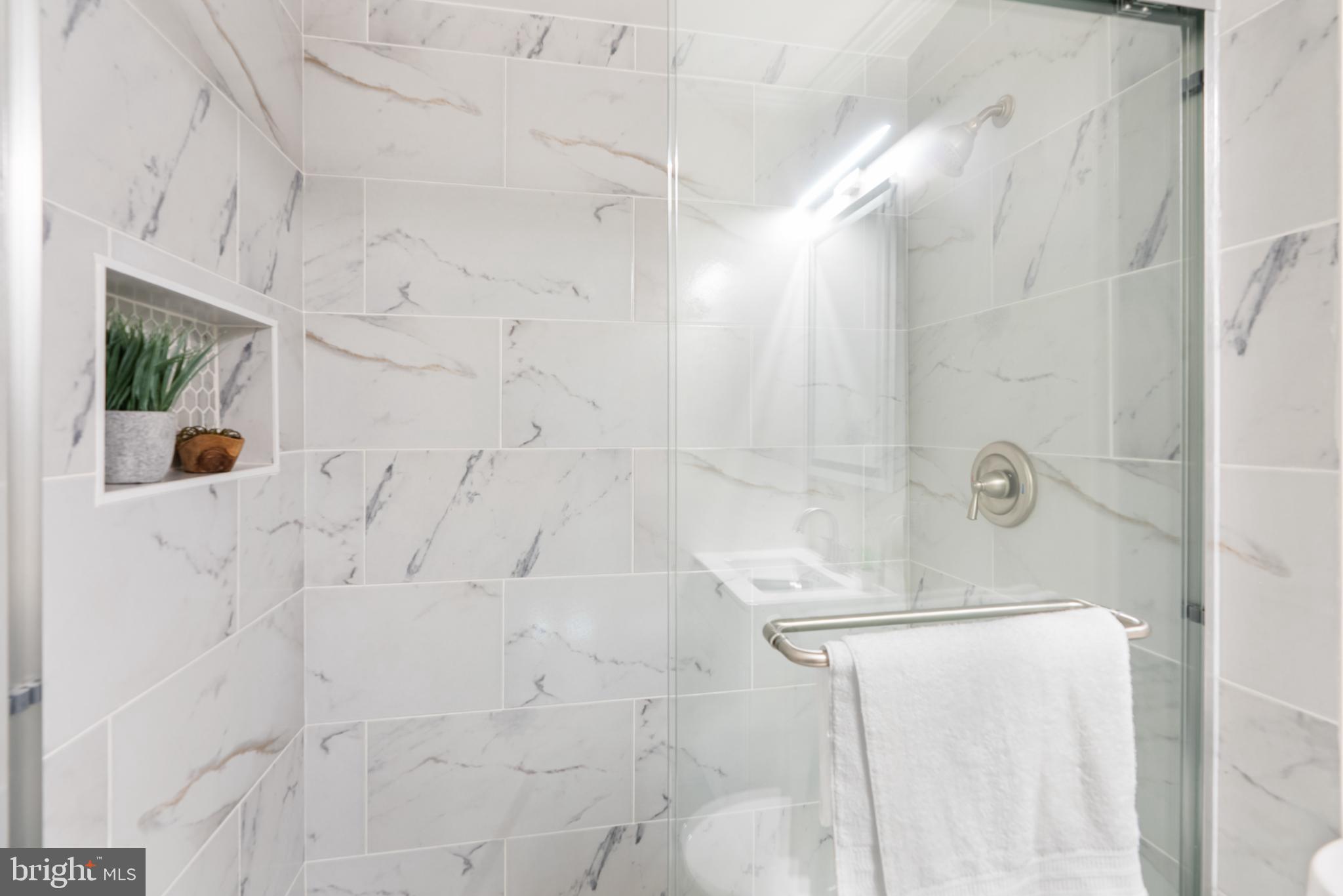 6430 Fourteenth Street Alexandria, VA 22307 - Photo 38 of 55 Sleek glass shower with elegant marble tiles.