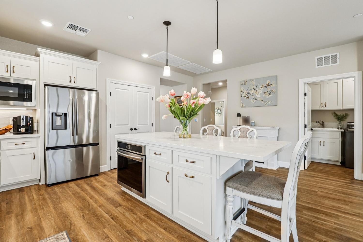 1124 North Palmer Road Galt, CA 95632 - Photo 11 of 41 a kitchen with stainless steel appliances kitchen island granite countertop a refrigerator a stove a sink dishwasher and a dining table with wooden floor