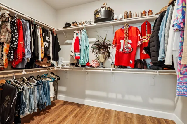 a view of walk in closet with clothes