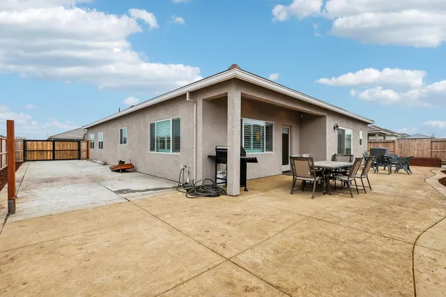 a view of house with backyard and sitting area