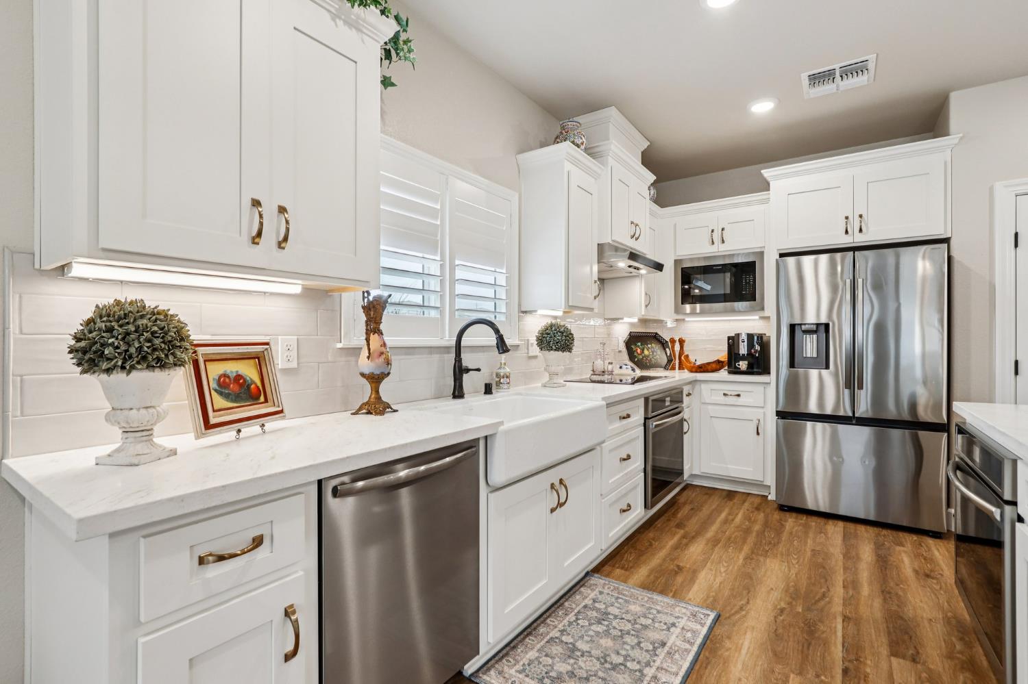 1124 North Palmer Road Galt, CA 95632 - Photo 10 of 41 a kitchen with stainless steel appliances a sink cabinets and wooden floor