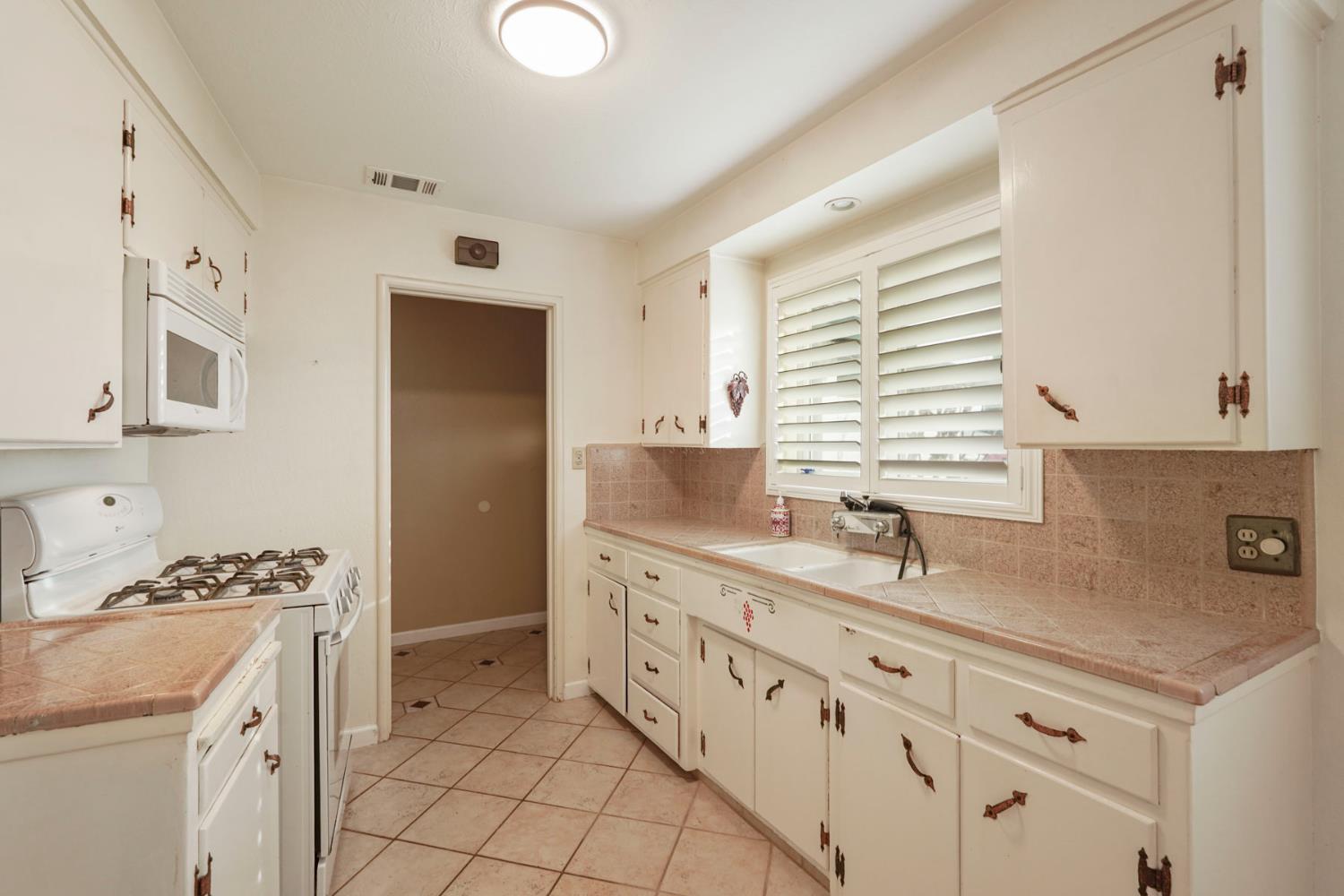 1007 Cardinal Street Lodi, CA 95240 - Photo 10 of 31 a kitchen with granite countertop a sink and a stove