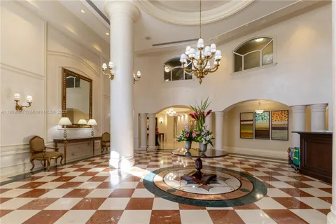 a lobby with a chandelier and dining table
