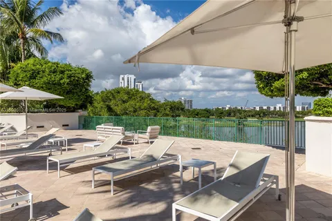 a view of a patio with couches table and chairs under an umbrella