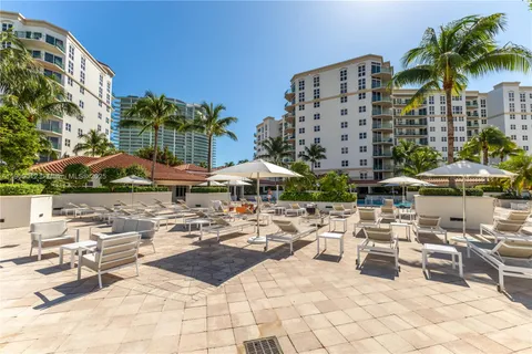 a view of a tall building with a lawn chairs under an umbrella