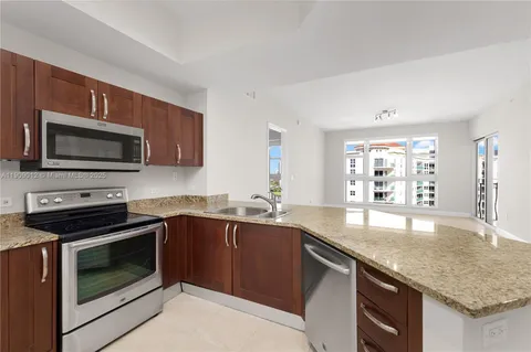 a kitchen with stainless steel appliances granite countertop a sink dishwasher stove microwave and refrigerator